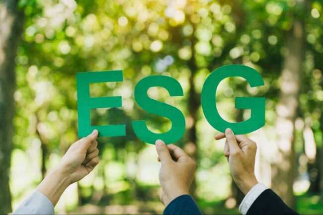 trzy ręce trzymające zielone litery ESG