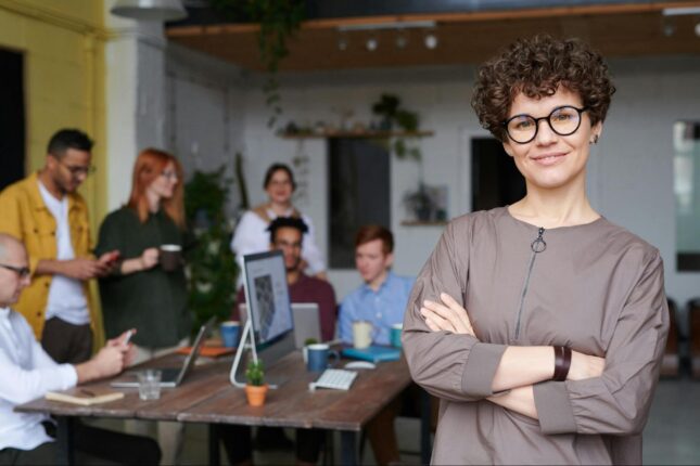 uśmiechnięta kobieta na tle grupy pracowników