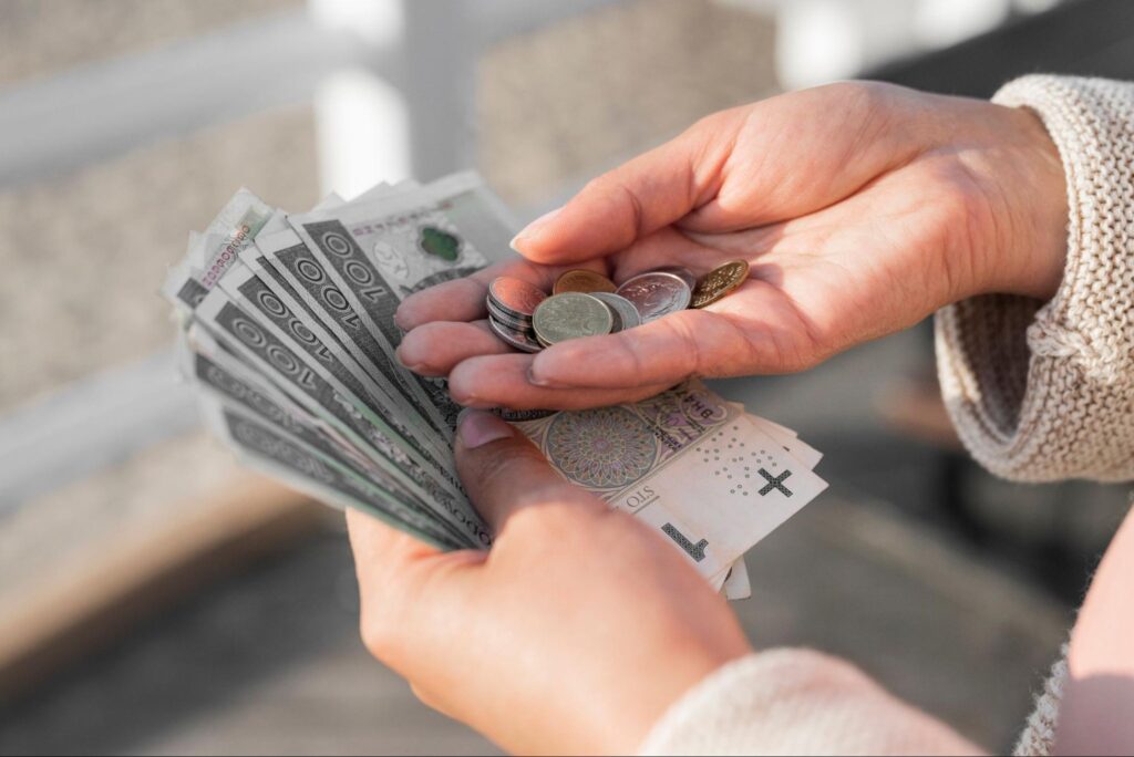 kobieta trzymająca w dłoniach banknoty i monety