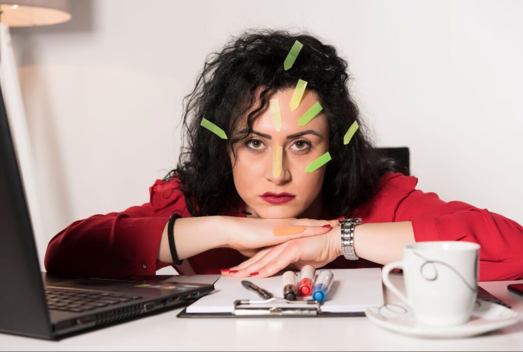 pracownica z licznymi fiszkami na twarzy, koncepcja prokrastynacji